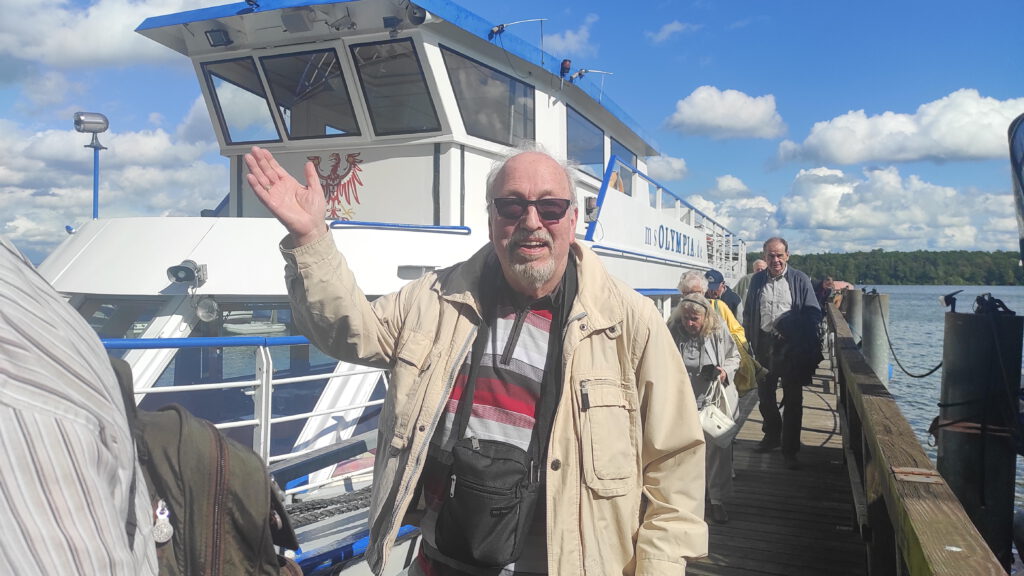 Gast winkt auf Steg vor Schiff
